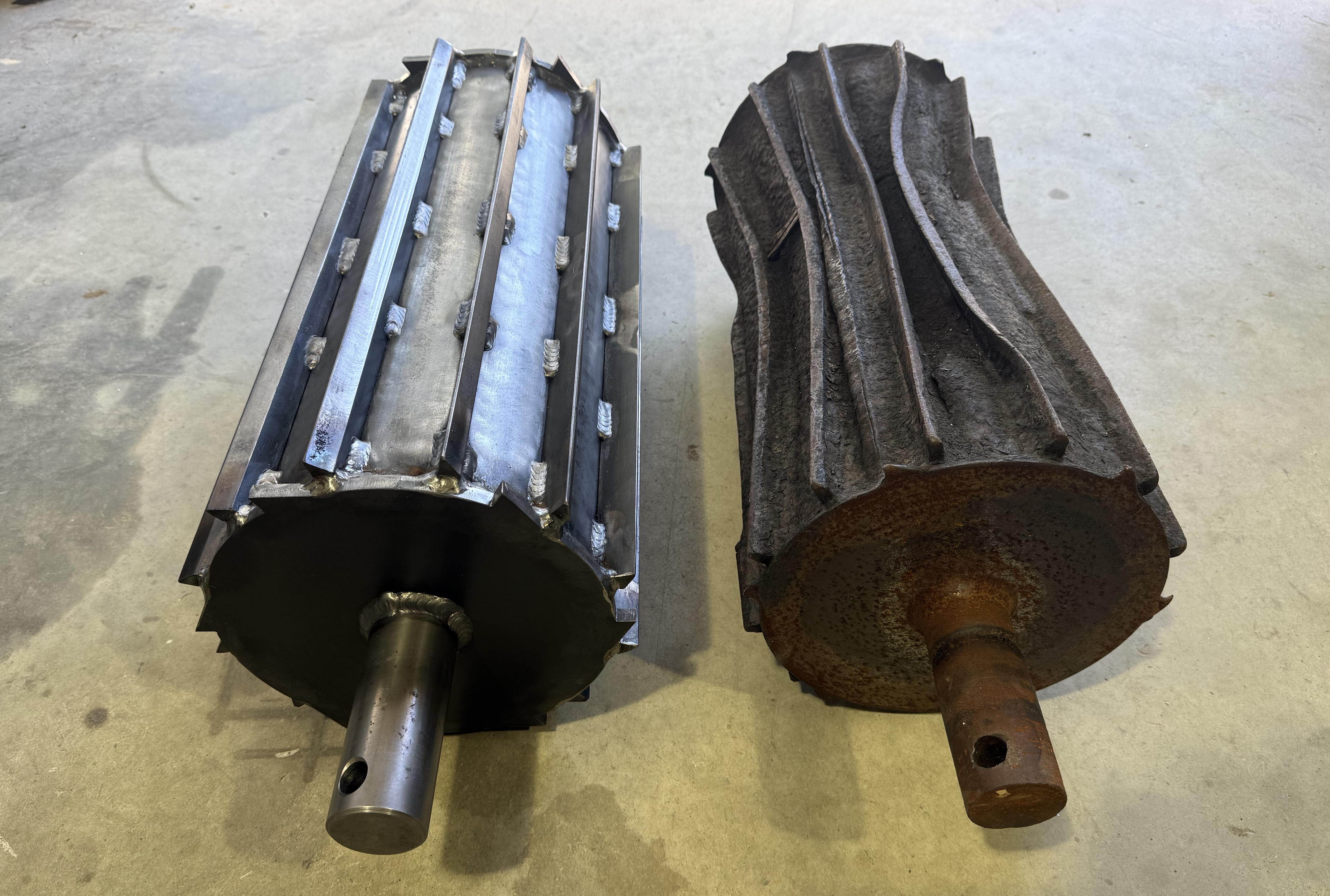 Rebuilt 1045 steel chipper feed roller with welded wear bars next to original worn roller